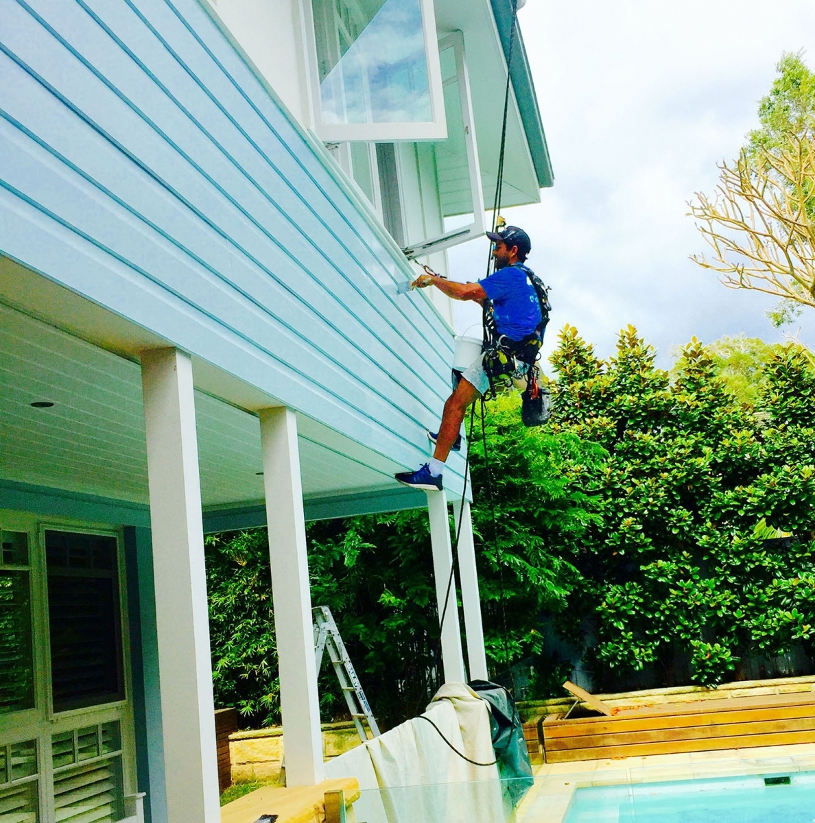 High Solutions Abseiling worker painting a building exterior using rope access